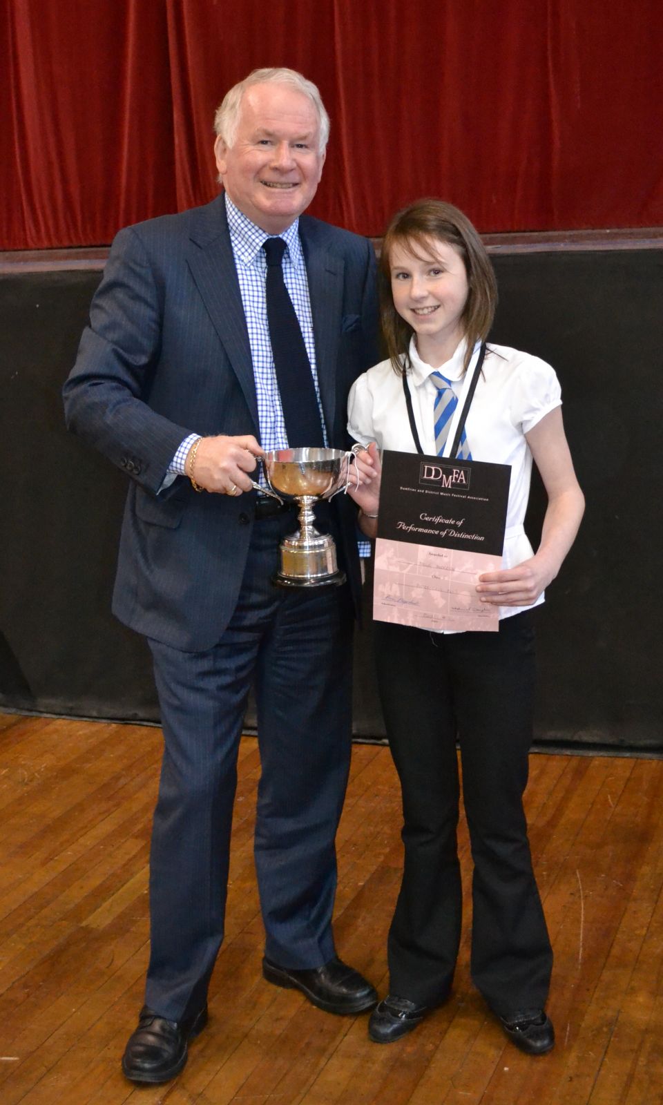 Class 5 winner Mollie Anderson from Sanquhar primary gets her trophy from adjudicator Brian Marjoribanks